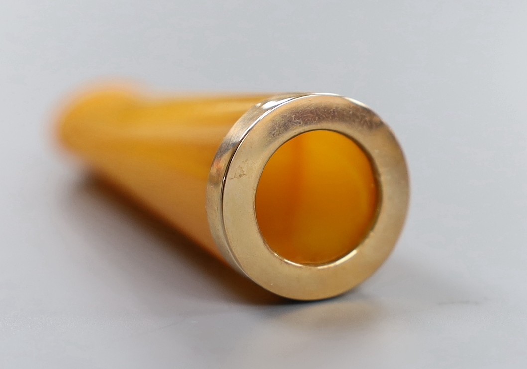 An 18ct and graduated cultured pearl set half hoop ring, size O/P, gross 5.2 grams, an Edwardian yellow metal, enamel, seed pearl and peridot brooch, an amber cig holder and a paste set clip?